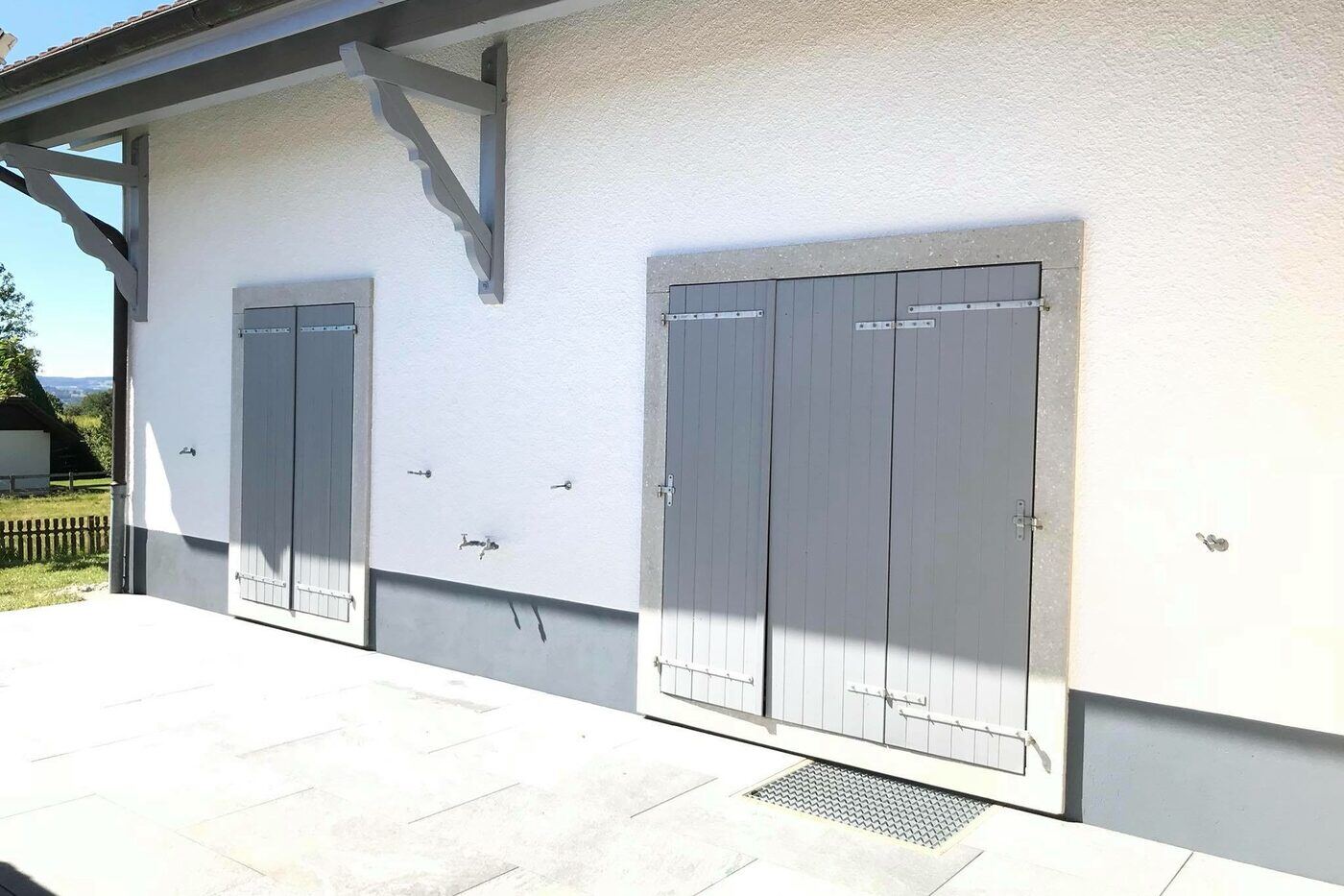 Façade crépie blanche et volets bois repeints après travaux