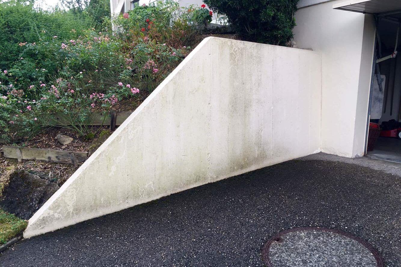 Muret de rampe d'accès avant travaux, béton gris encrassé