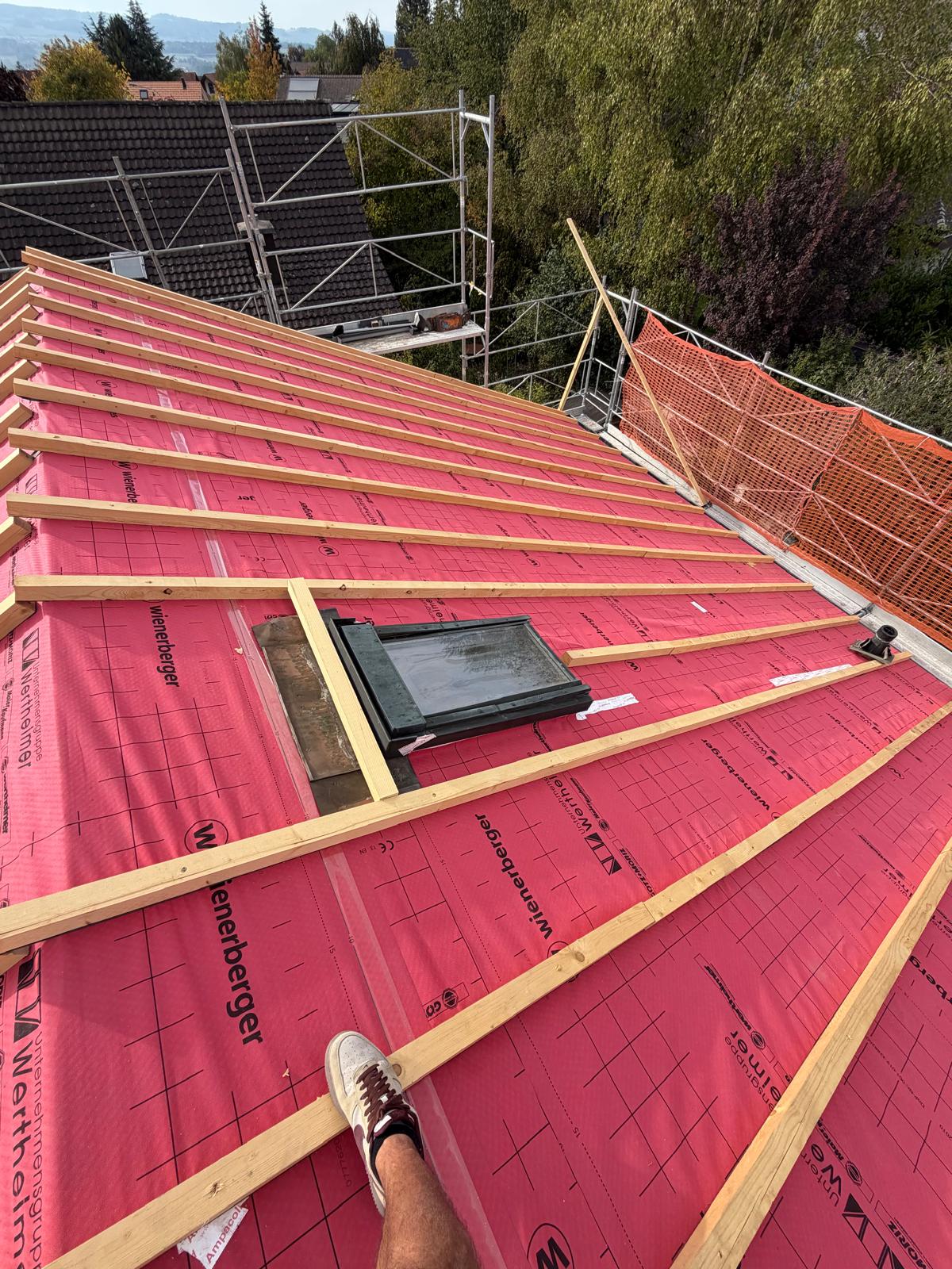 Sous-toiture neuve et lattage posés autour d'une fenêtre de toit, avant la pose des tuiles