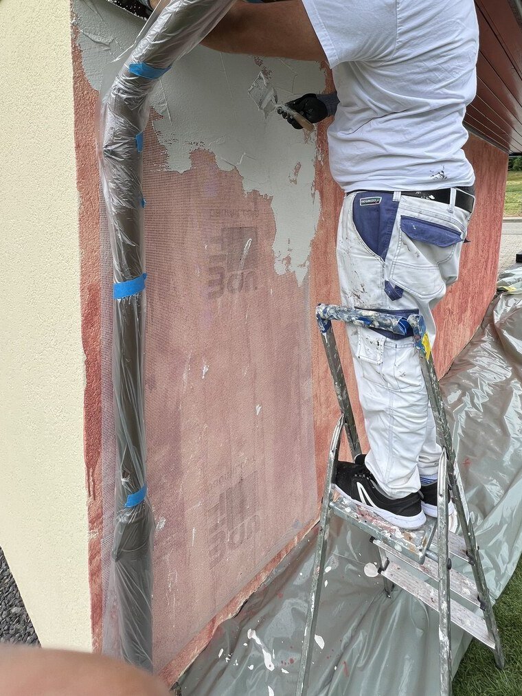Pose de la sous-couche sur une façade, protections en place